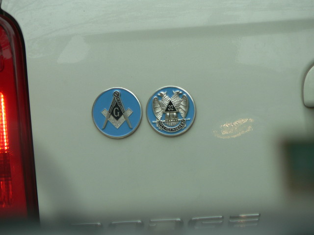 Seen on the back of a van, I recognize the first one; the second is a mystery.