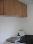 The cabinets above the toilet and the bench.