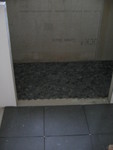 Dividing area between the shower and the rest of the bathroom. It will be river rock in the gap too.