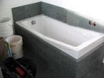The tub box and tiling behind the tub are completed.