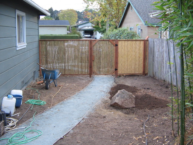 The gate on the fence dividing the front and the back.